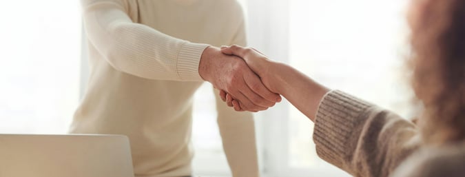 insurance agent interacting with a client, shaking hands